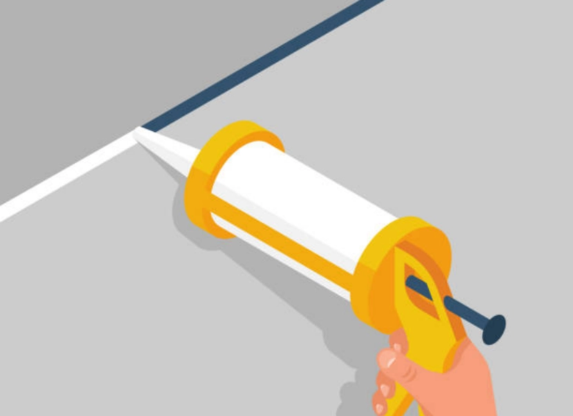 The worker holds a caulk gun in hand