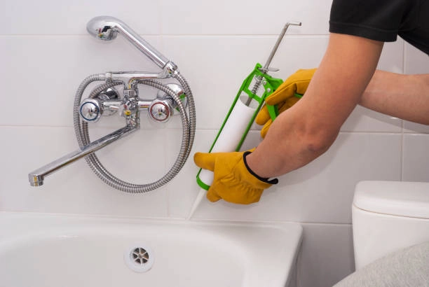 plumber apply silicone sealant to the joint bathtubs and ceramic tile